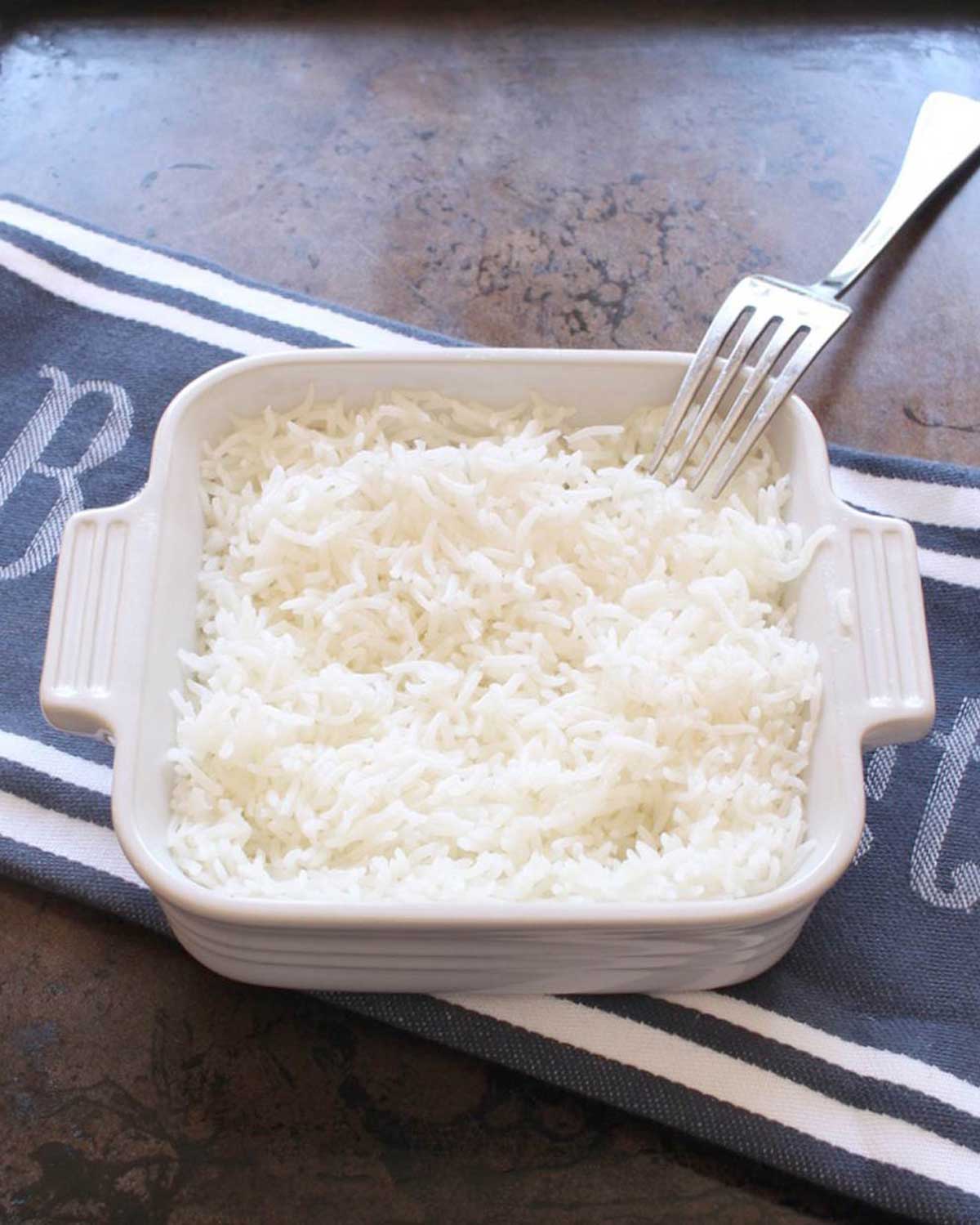 a bowl of baked rice on a blue and white napkin.