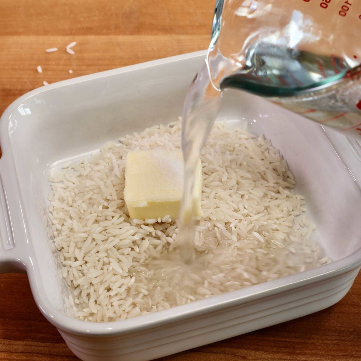 pouring water into a bowl of rice.