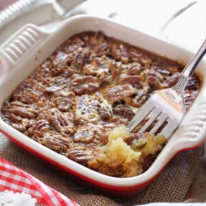 a small pecan pie in a red baking dish.