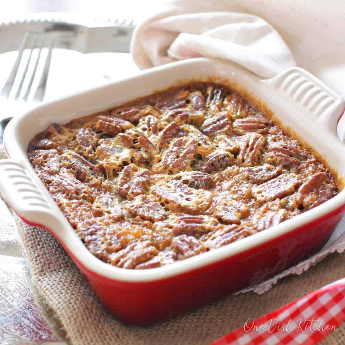 a single serve pecan pie in a red square baking dish.