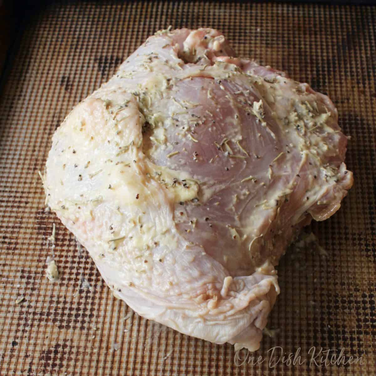 A raw turkey breast on a baking sheet 