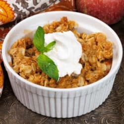 one small apple crisp in a white ramekin on a silver tray