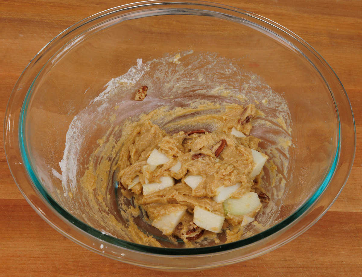 apple muffin batter with pecans in a mixing bowl