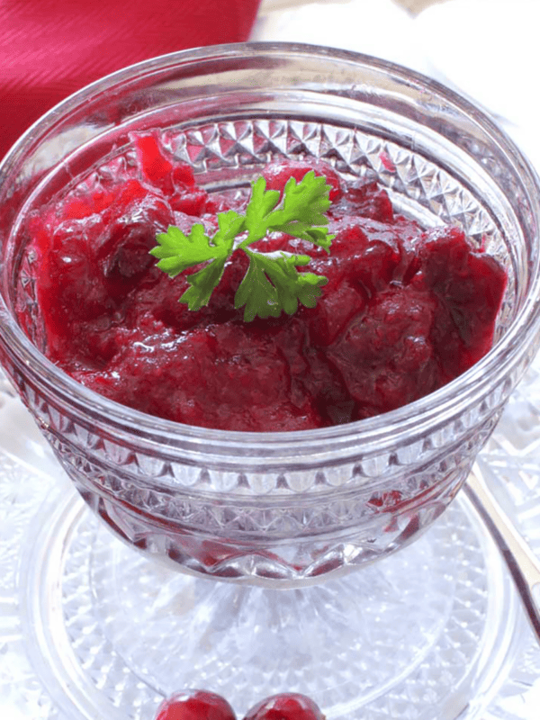 a gray bowl of cranberry sauce next to a red napkin