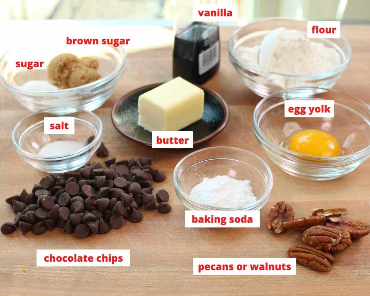 the ingredients needed to make one large chocolate chip cookie spread out on a brown table.