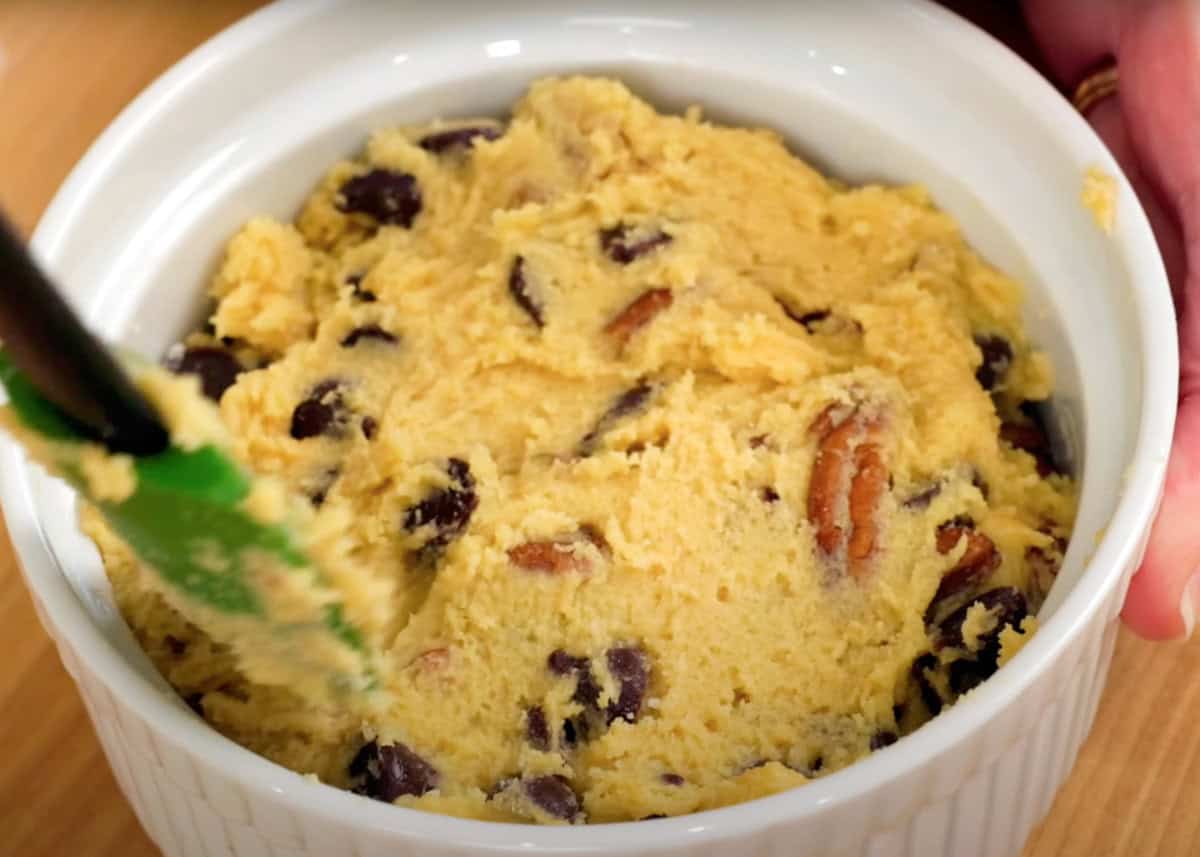 spooning chocolate chip cookie dough into a small ramekin.