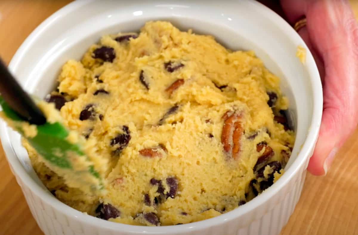 spooning chocolate chip cookie dough into a small ramekin.