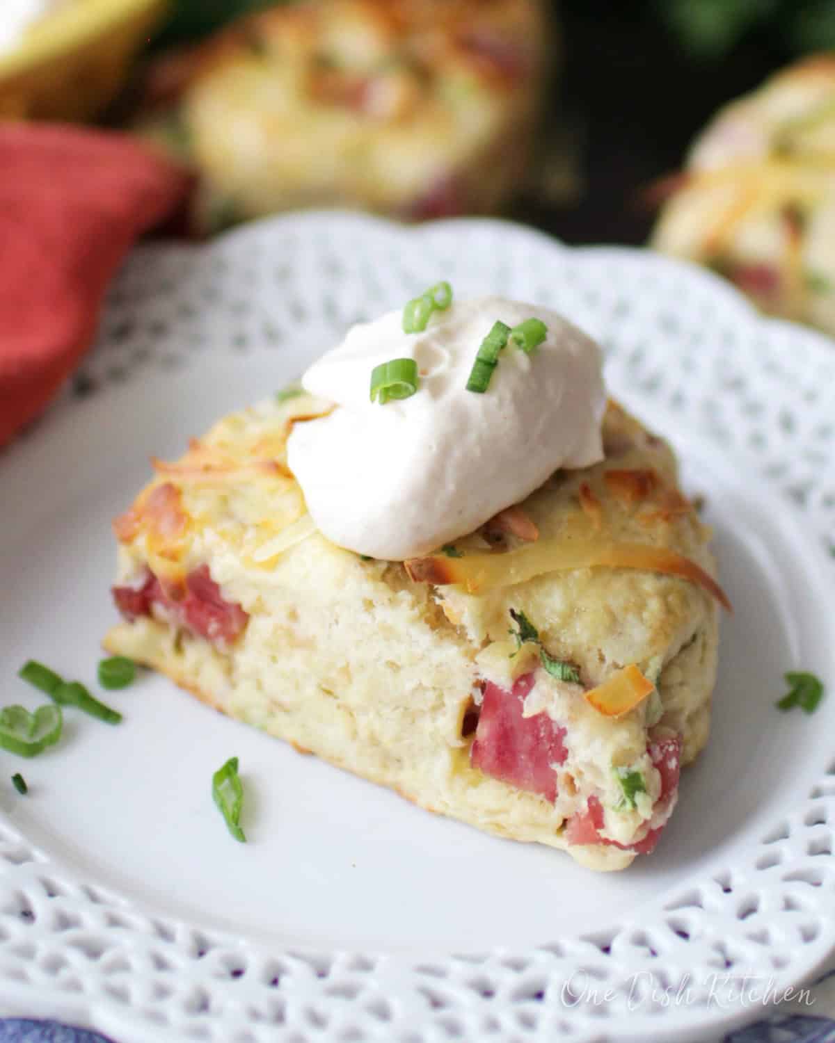 one ham scone on a white plate next to two scones.