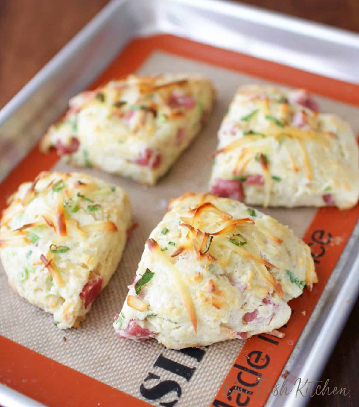 four ham and cheese scones on a small baking sheet.