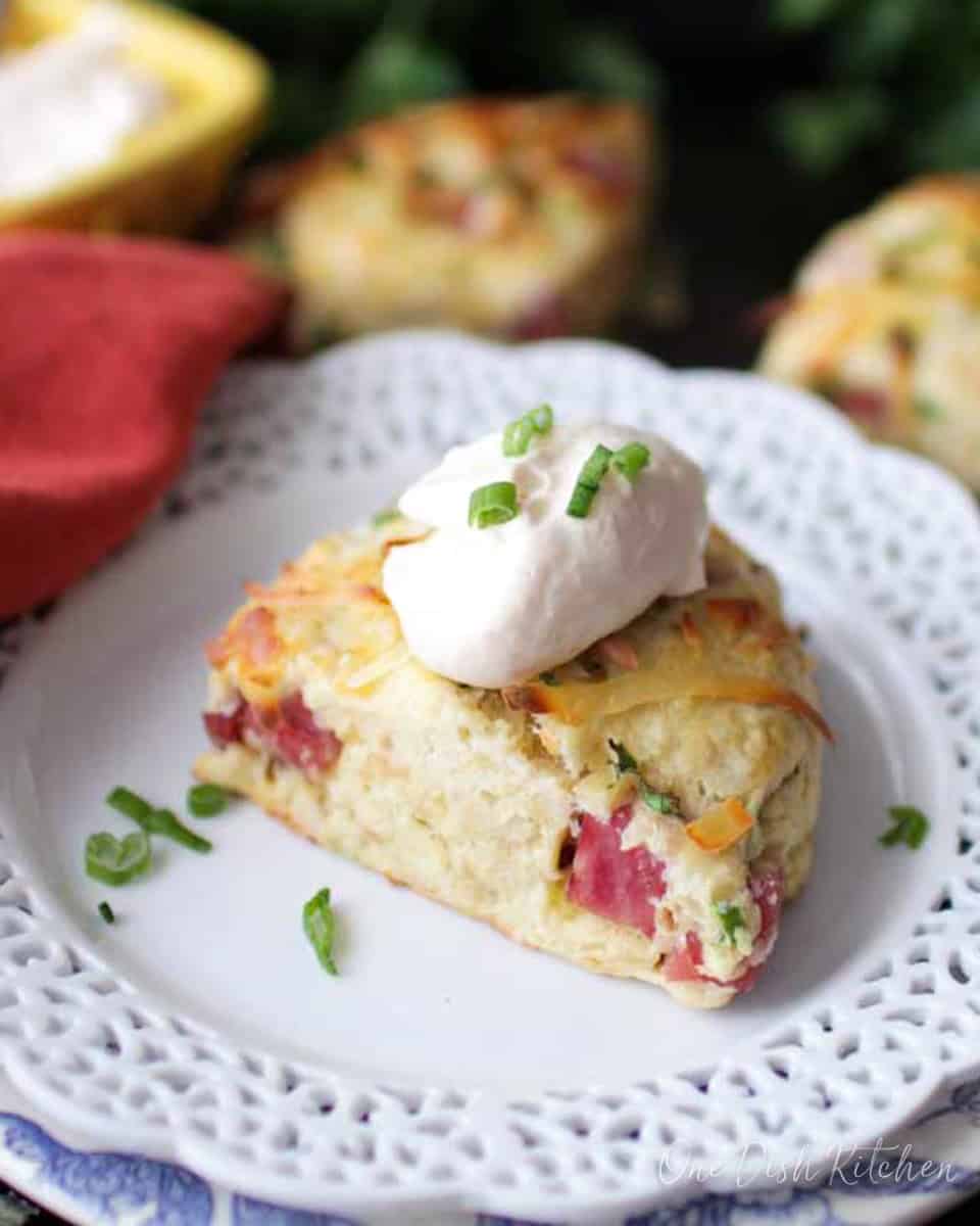 one ham scone on a white plate next to two scones.