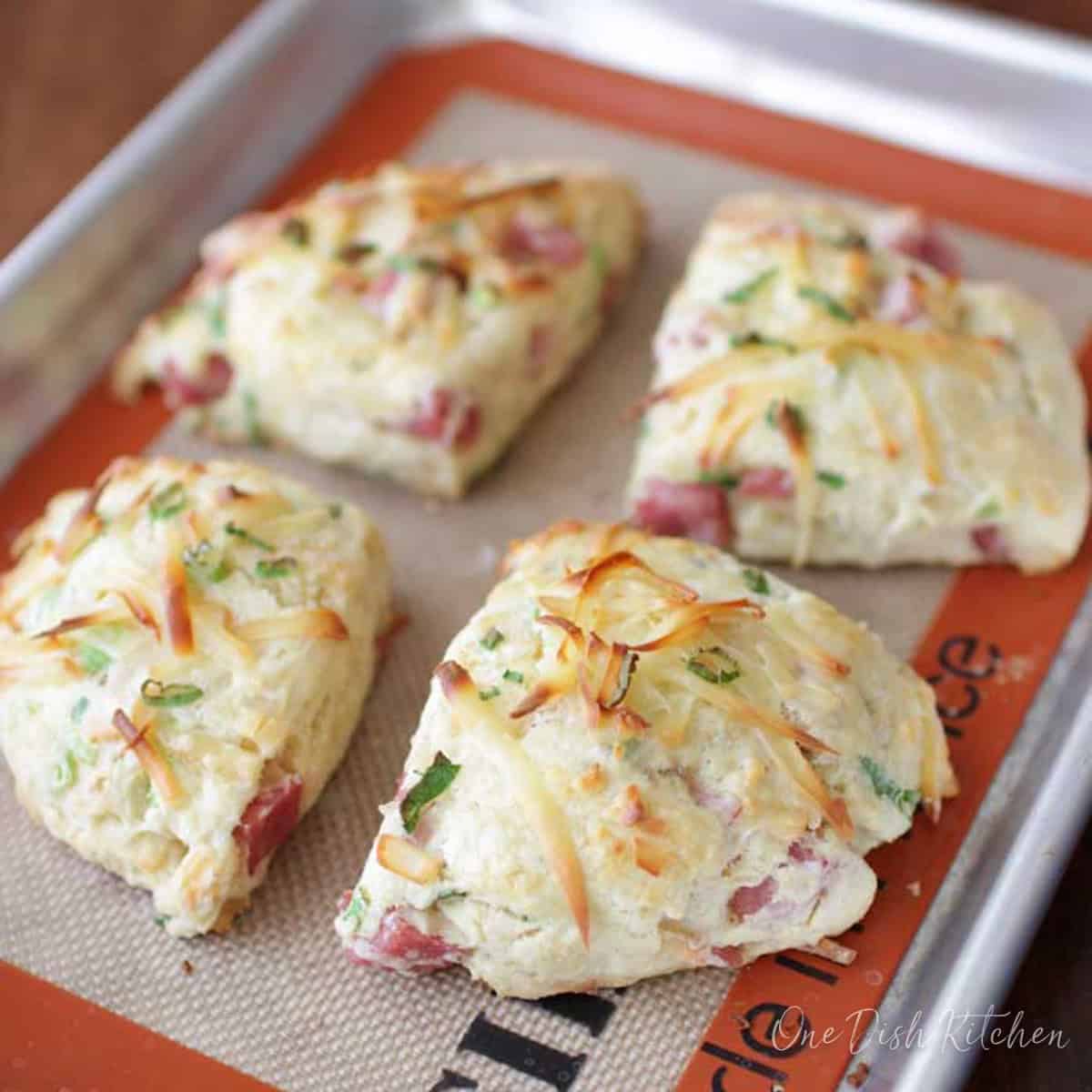 four ham and cheese scones on a small baking sheet.