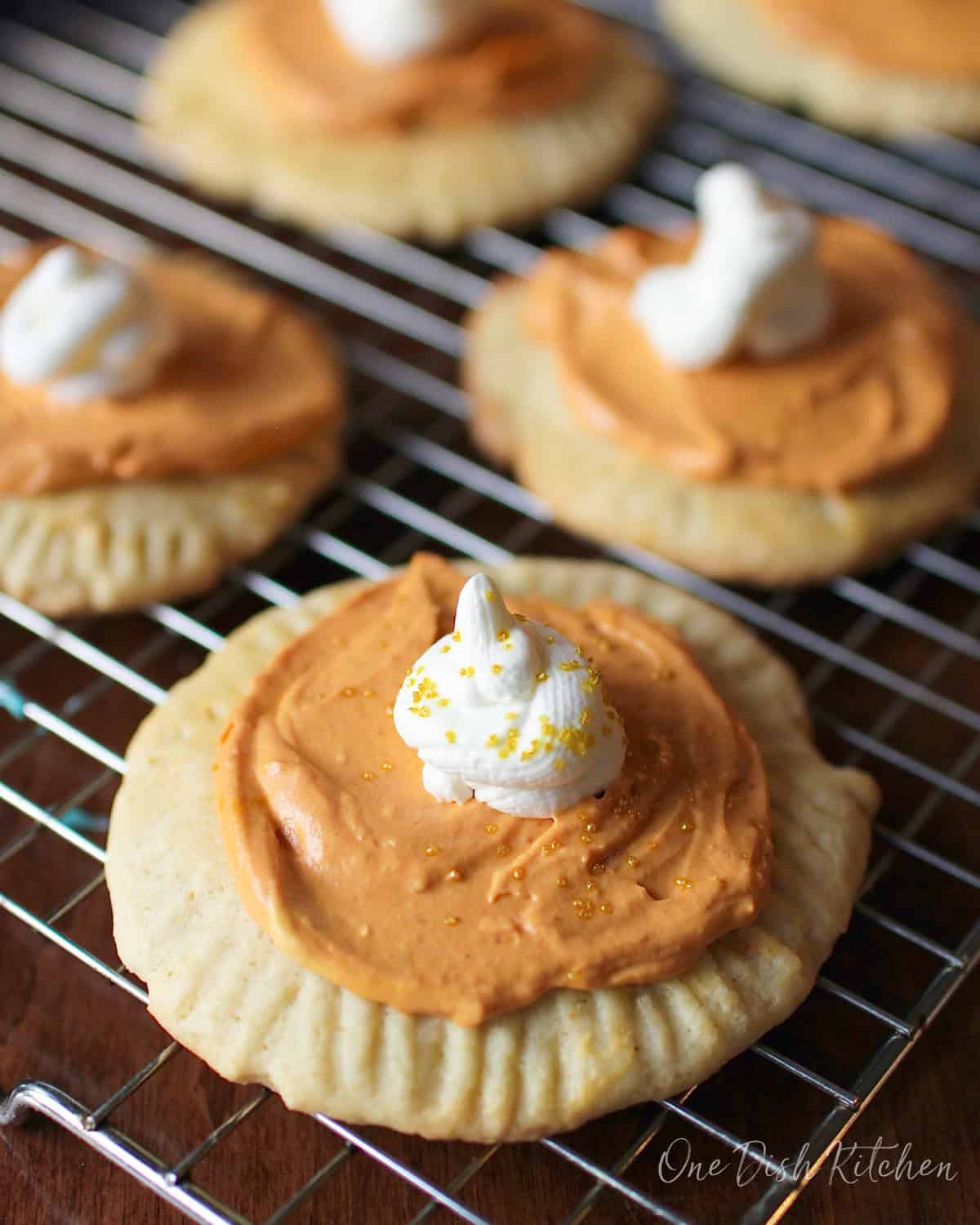 a small batch of pumpkin sugar cookies on a cooling rack.