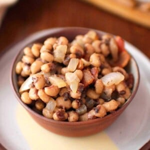 a small bowl of black eyed peas on a blue plate