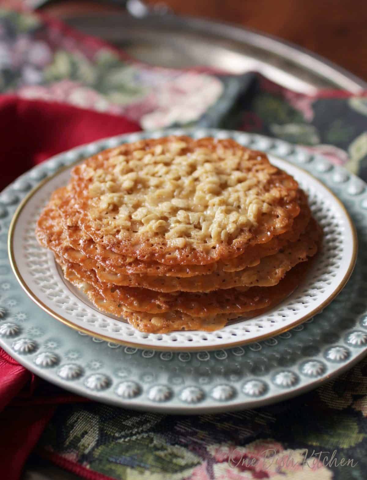 Five lace cookies stacked on a plate 
