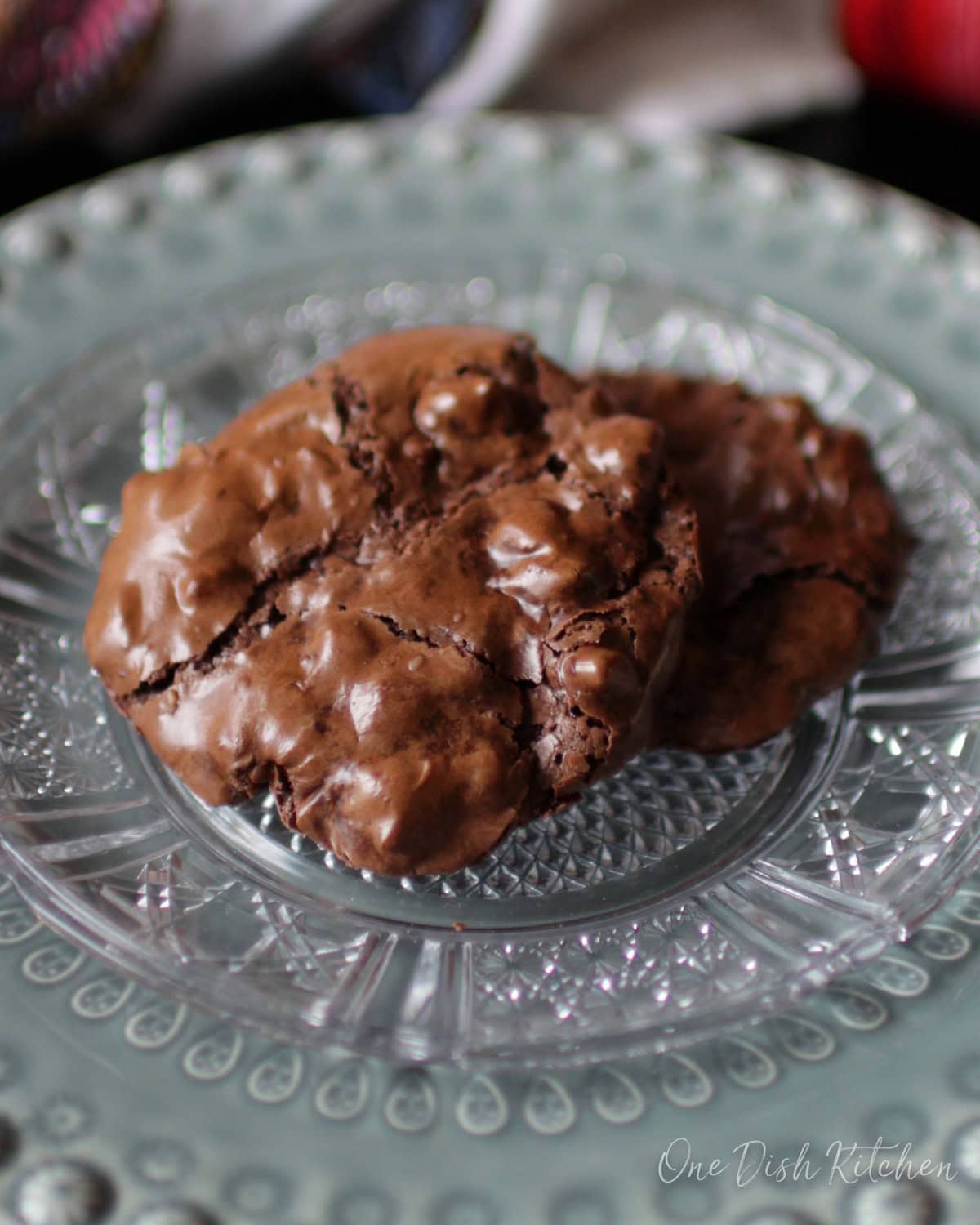 two flourless chocolate cookies on a green plate.