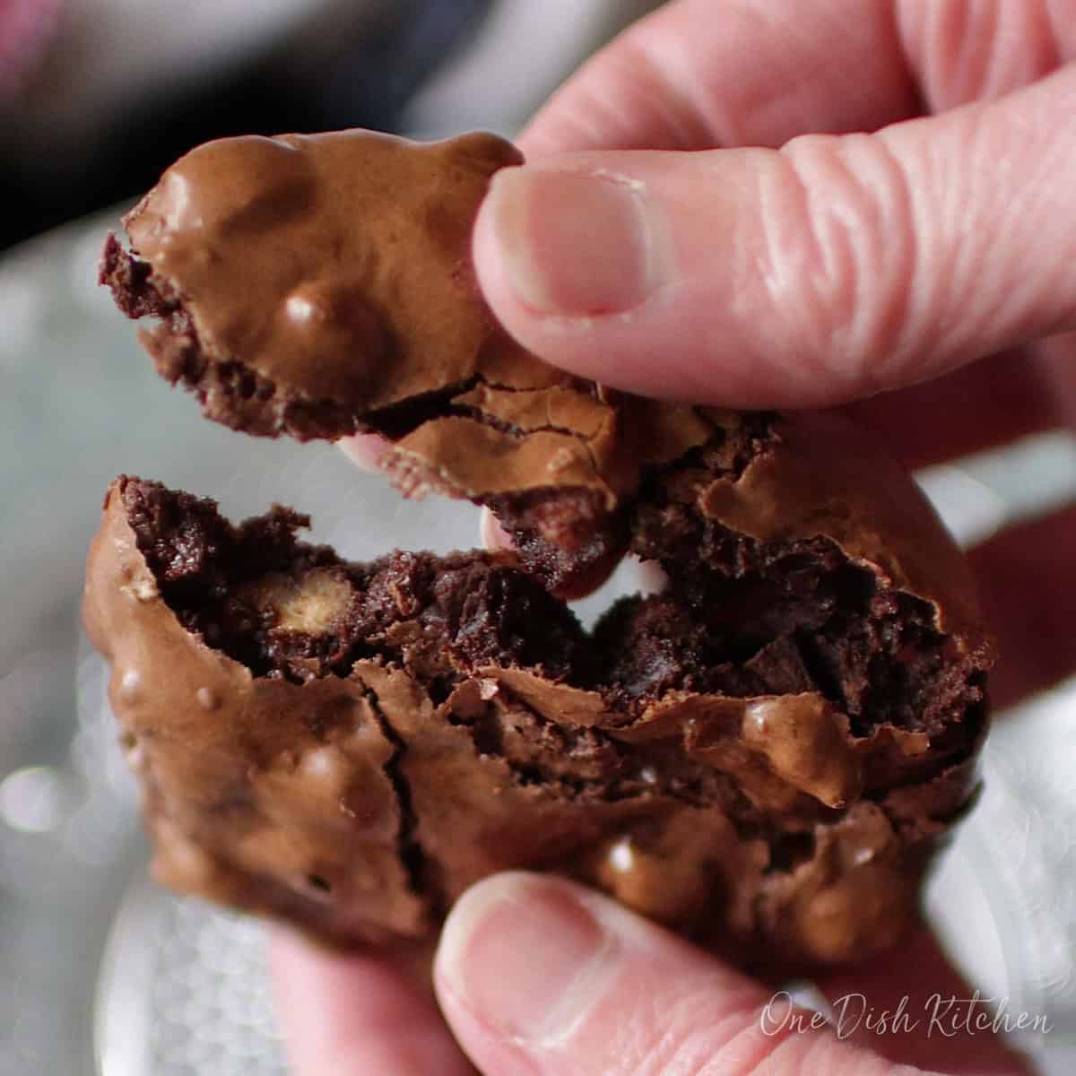 a flourless chocolate cookie broken in half.