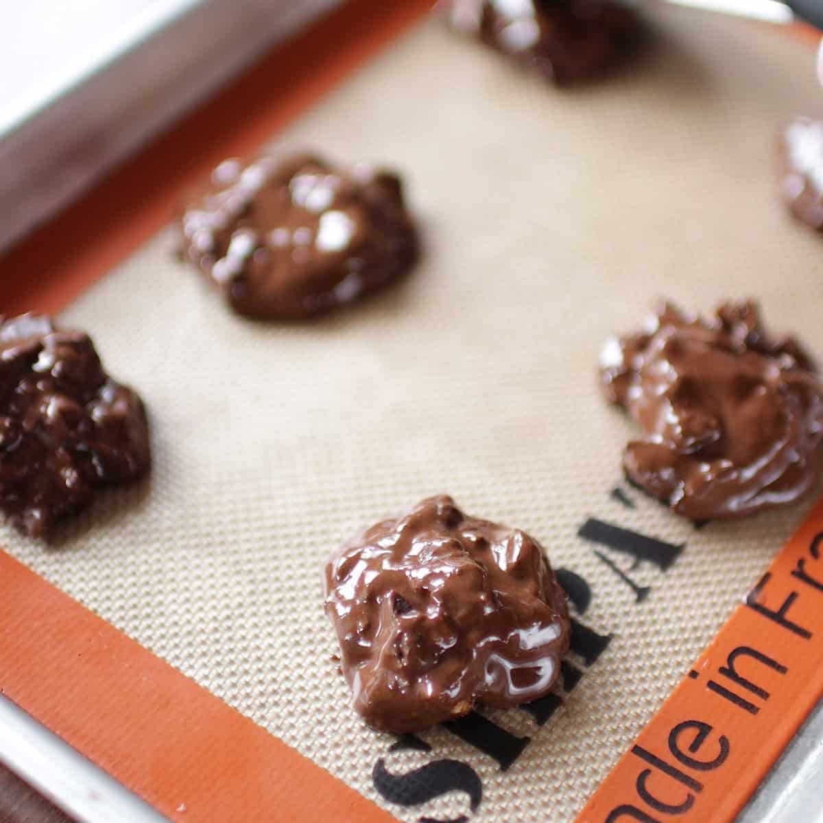 unbaked flourless chocolate cookies on a baking sheet.