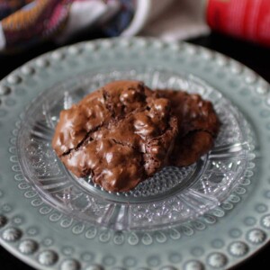 two flourless chocolate cookies on a green plate