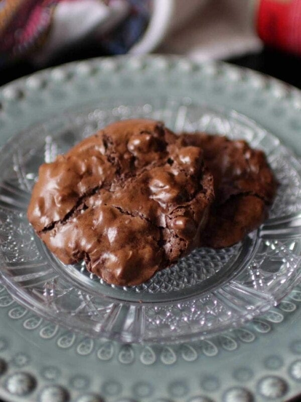 two flourless chocolate cookies on a green plate