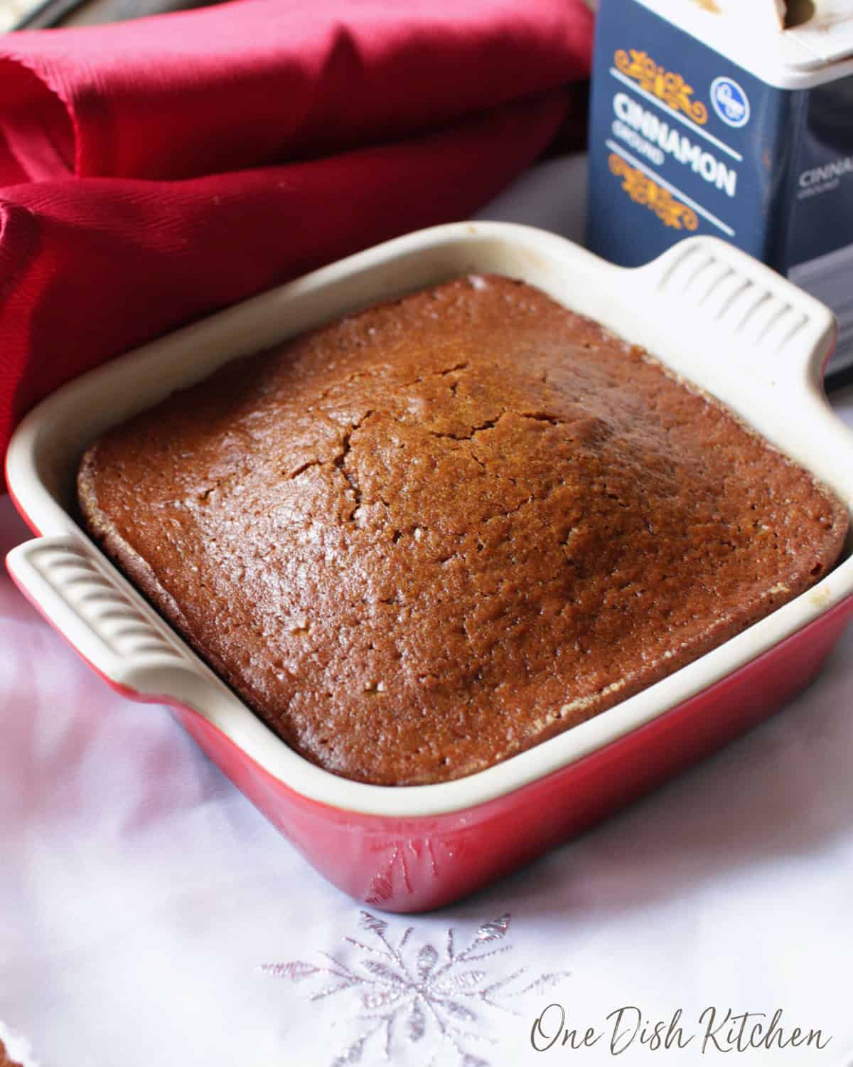 a small gingerbread cake in a red baking dish.