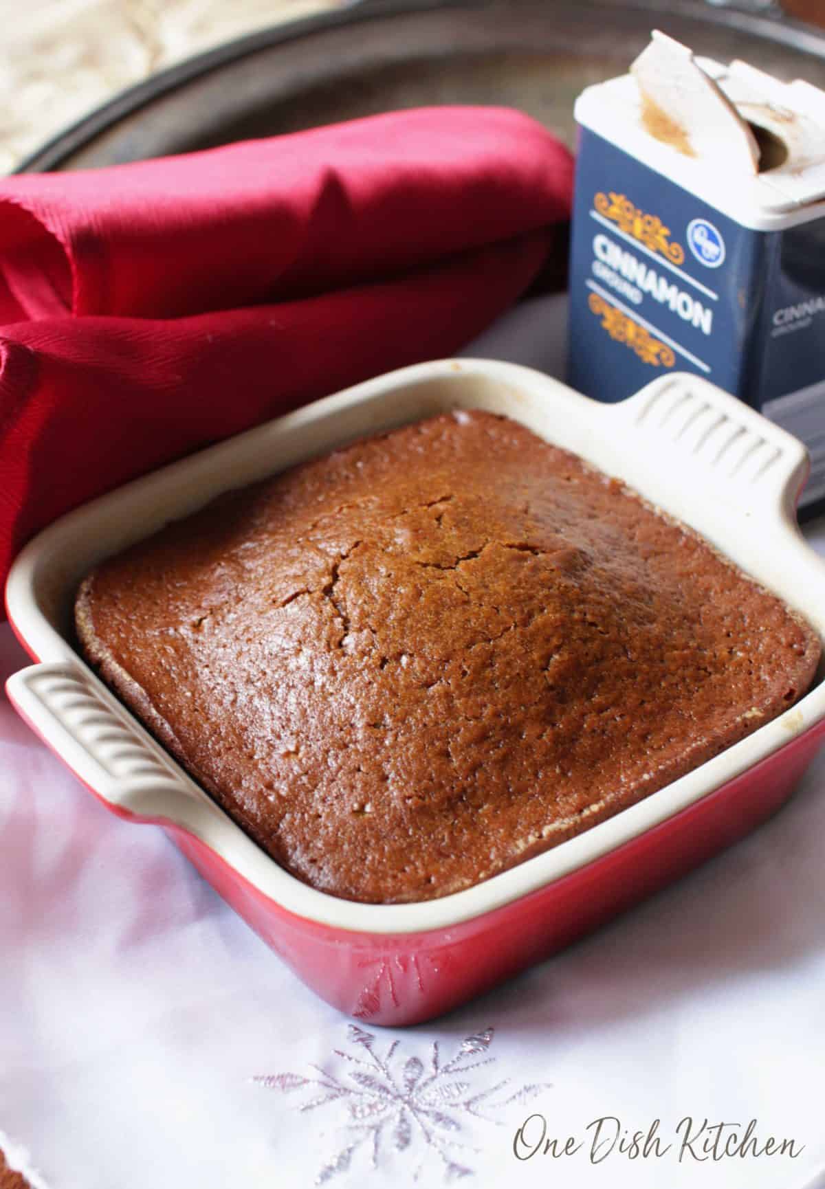 a small gingerbread cake in a red baking dish.