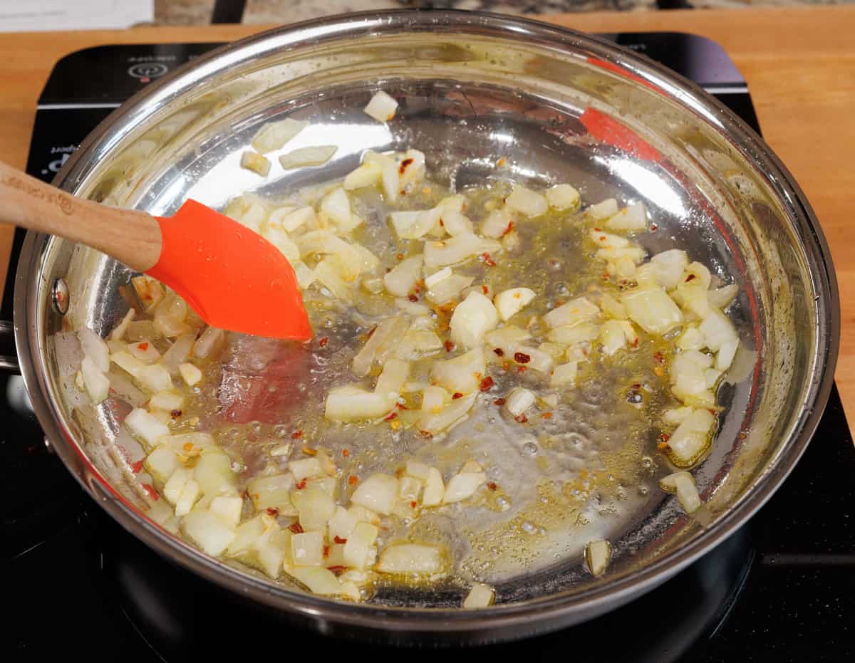 vodka cooking down with onions in a skillet