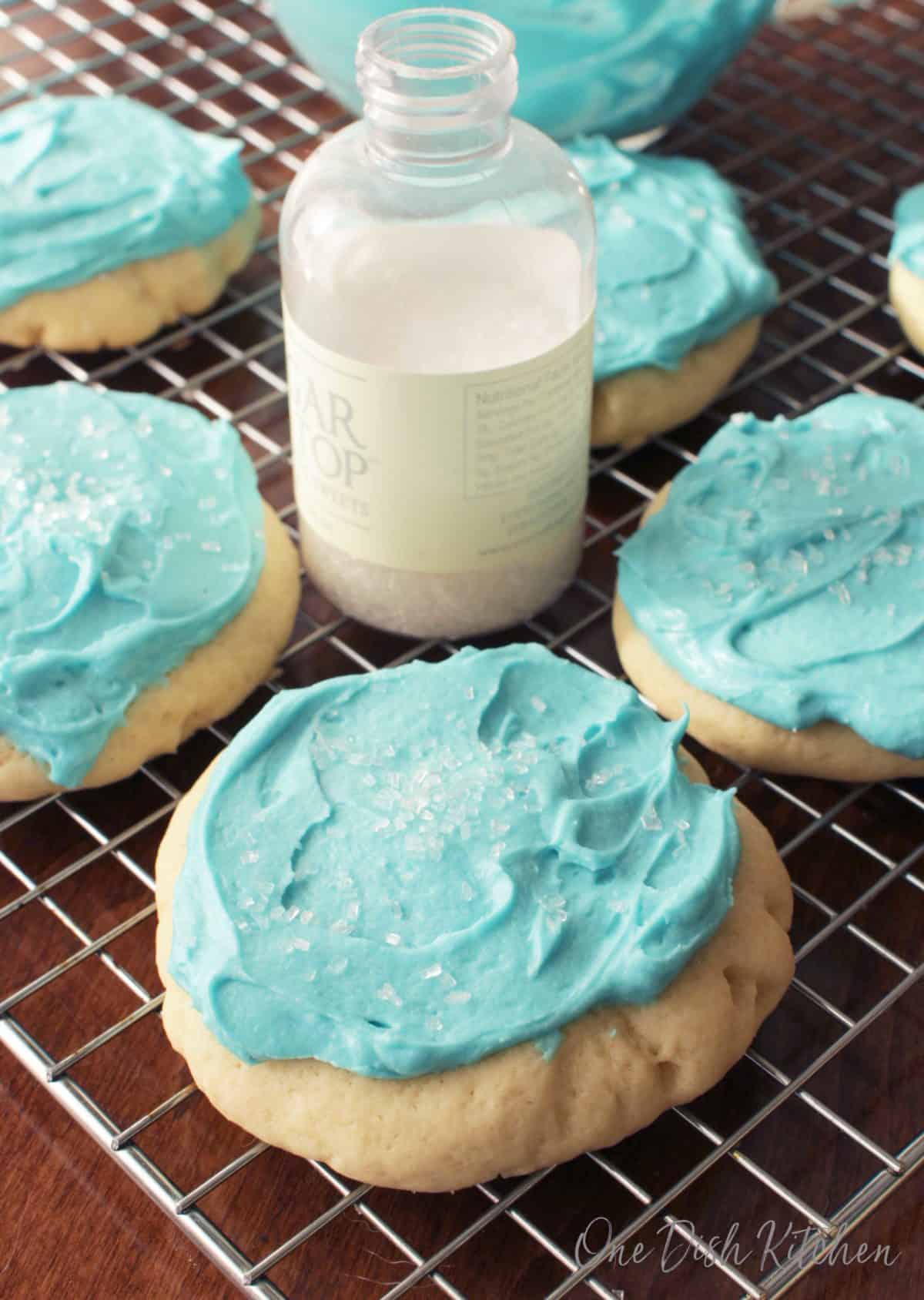 Blue Frosted Lofthouse Sugar Cookies with white crystal sprinkles on a cooling rack 