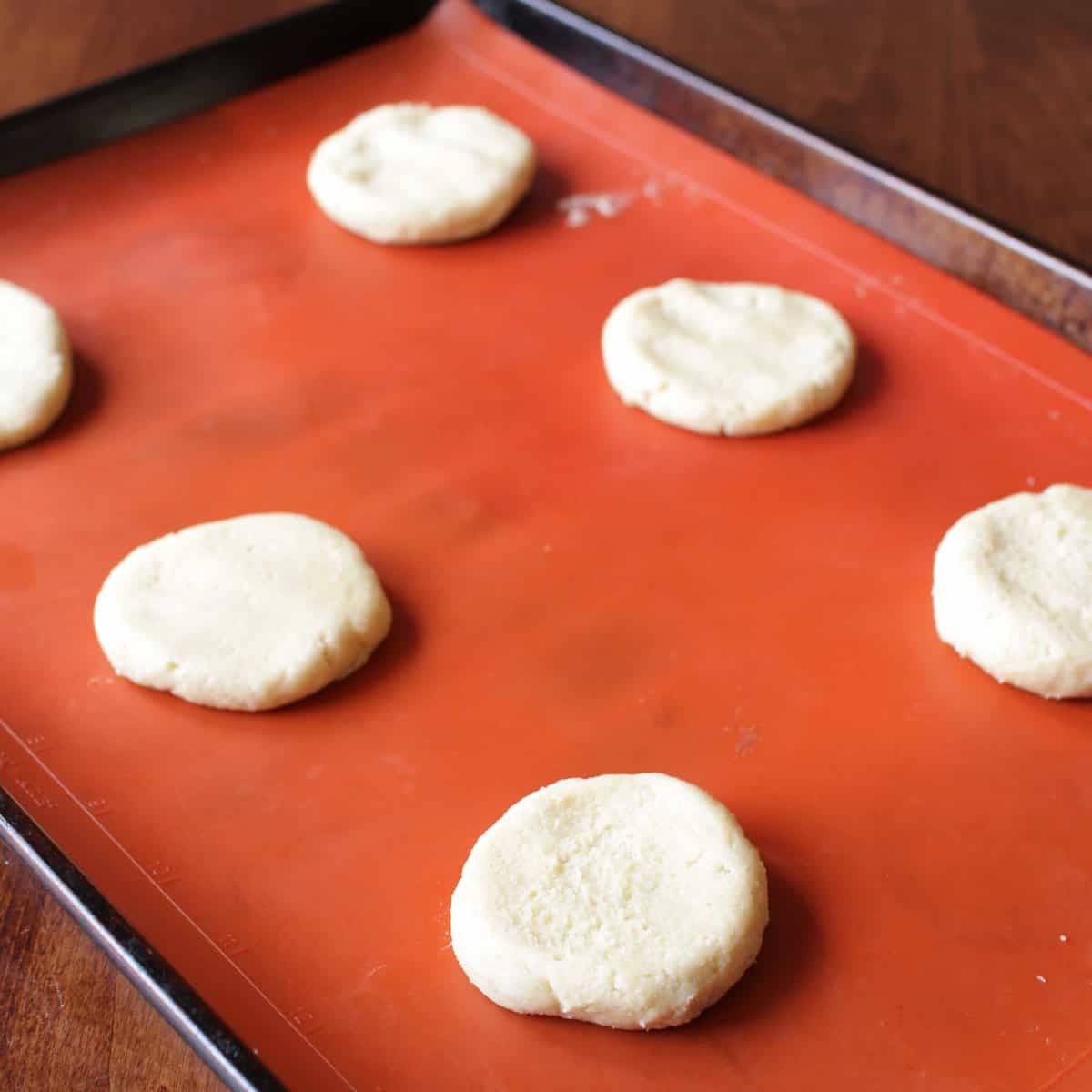 6 cookies ready to be baked in an oven on a baking sheet.