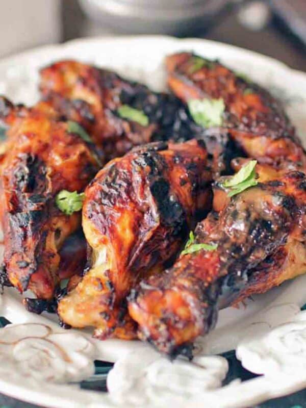 six baked Chicken Wings on a white plate.