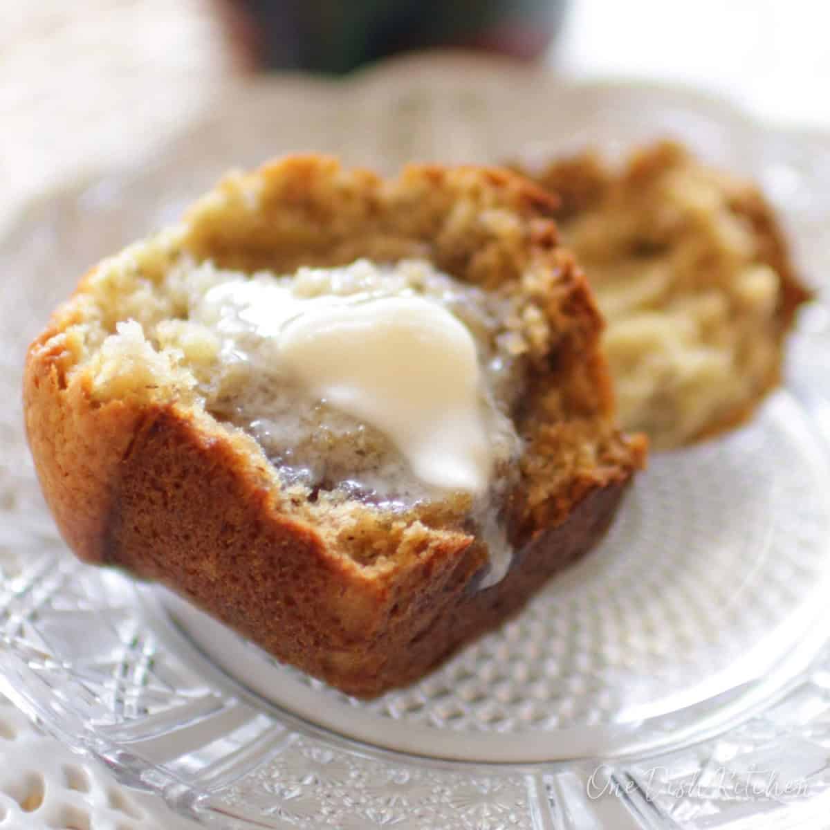 Butter melting on a muffin half and dripping onto the plate.