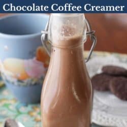 a small bottle of chocolate coffee creamer next to a cup of coffee.