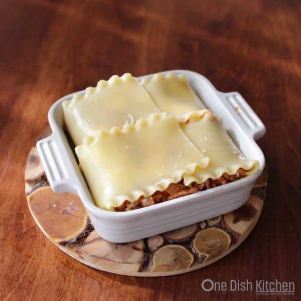 lasagna preparation with noodle folded over meat and cheese filling