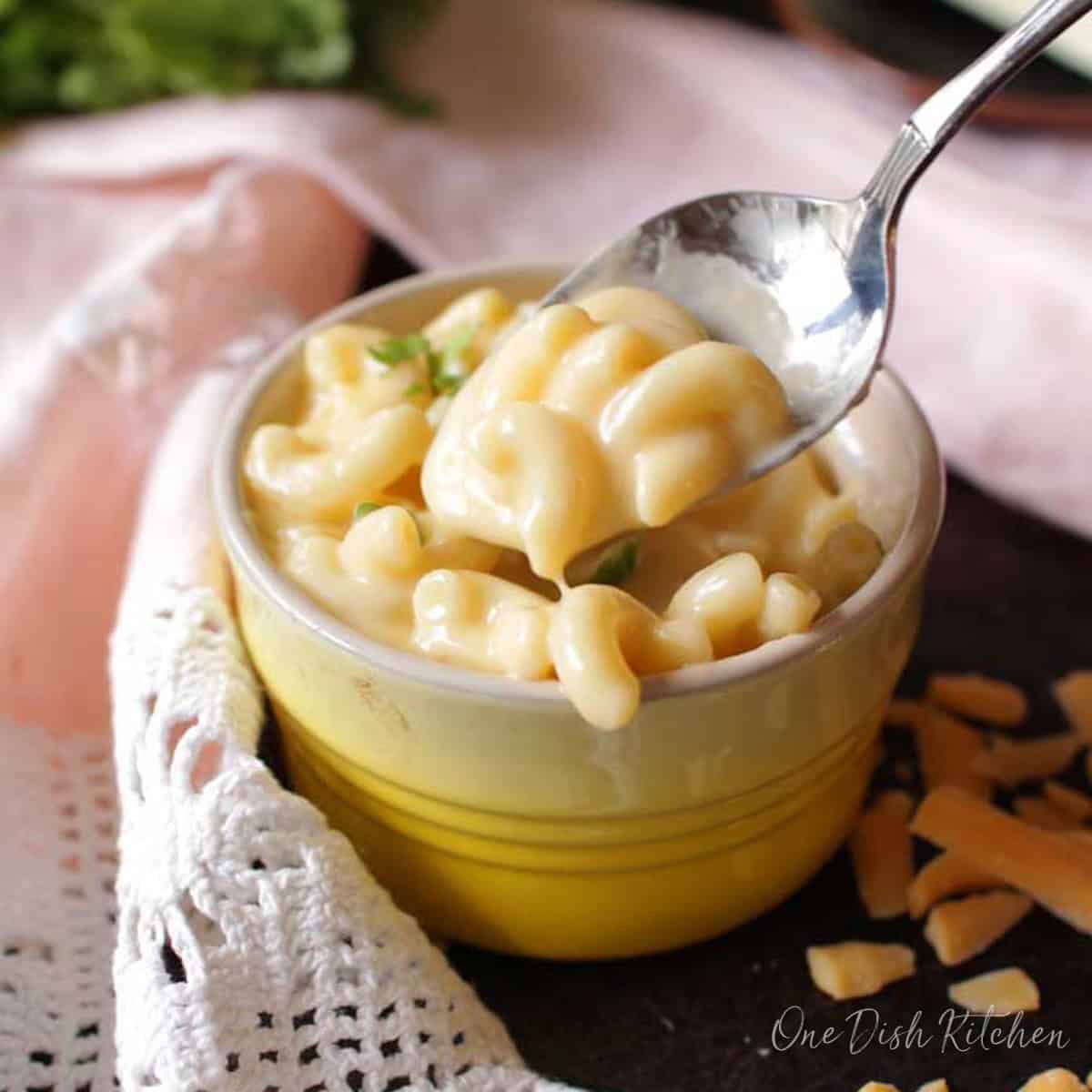 A spoonful of macaroni and cheese from a small bowl.
