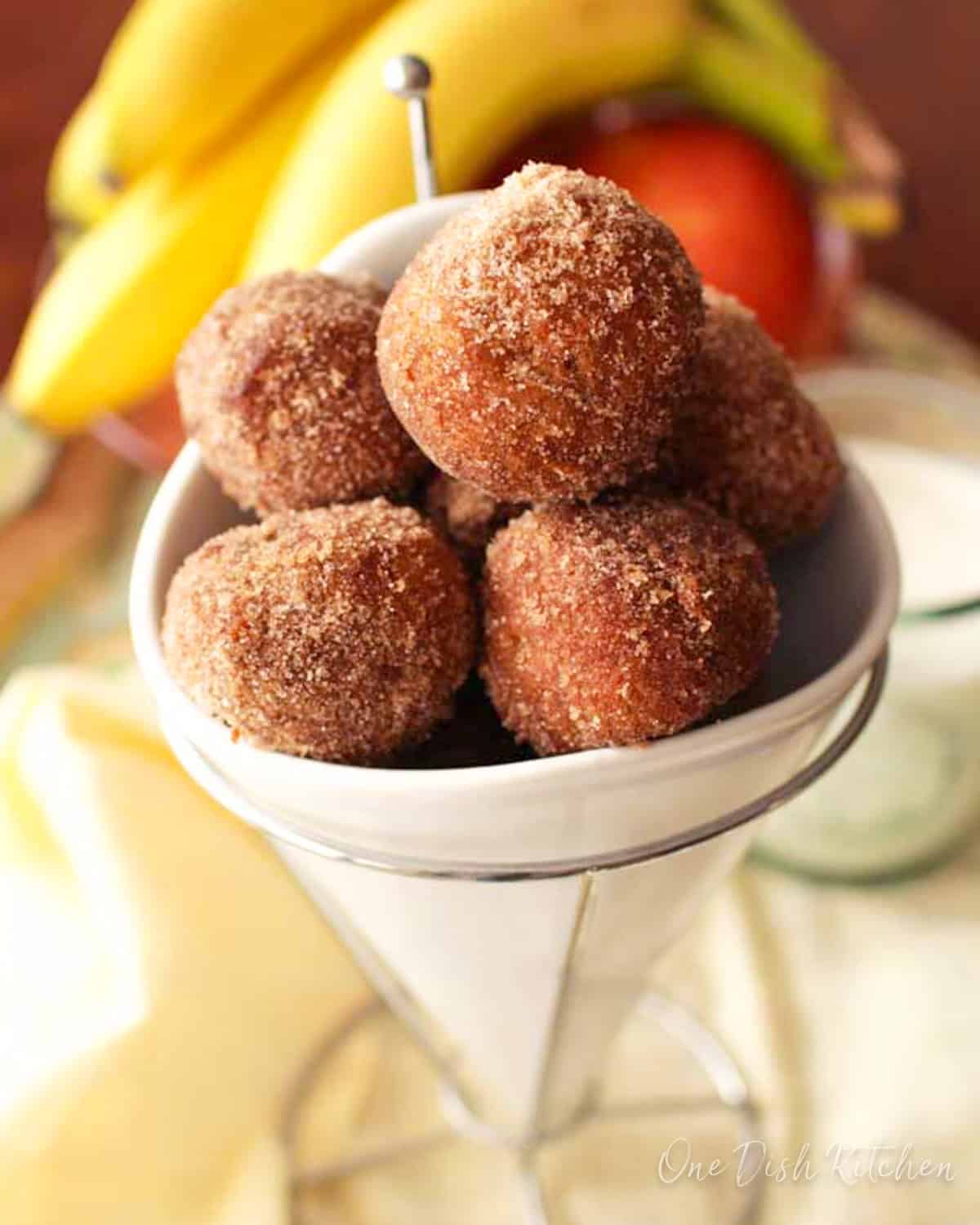 cinnamon sugar donut holes in a white bowl.