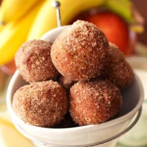 cinnamon sugar donut holes in a white bowl.