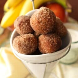 six donut holes in a white bowl.