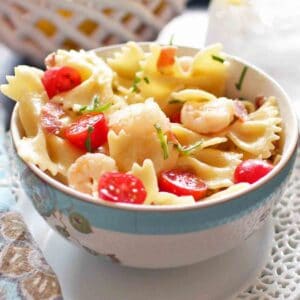 Shrimp and Prosciutto Pasta with cherry tomatoes in a white bowl.