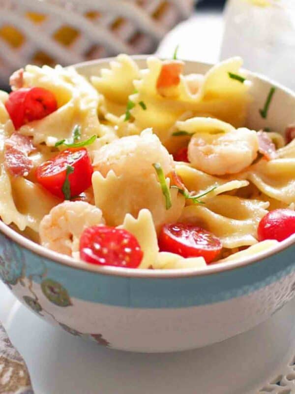 Shrimp and Prosciutto Pasta with cherry tomatoes in a white bowl.