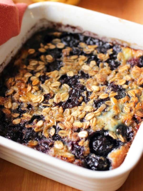 baked oatmeal with blueberries in a square white baking dish.