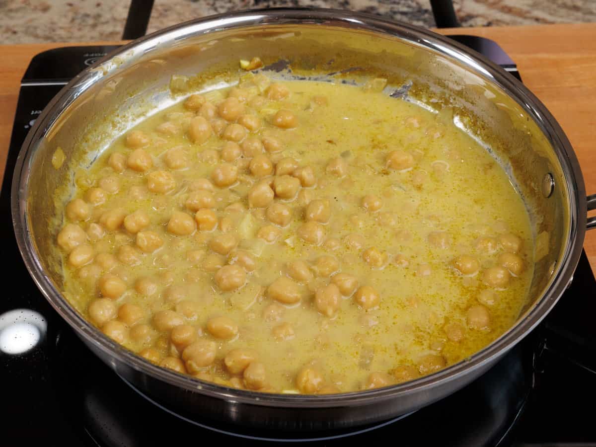 chickpea curry simmering in a pot on the stove
