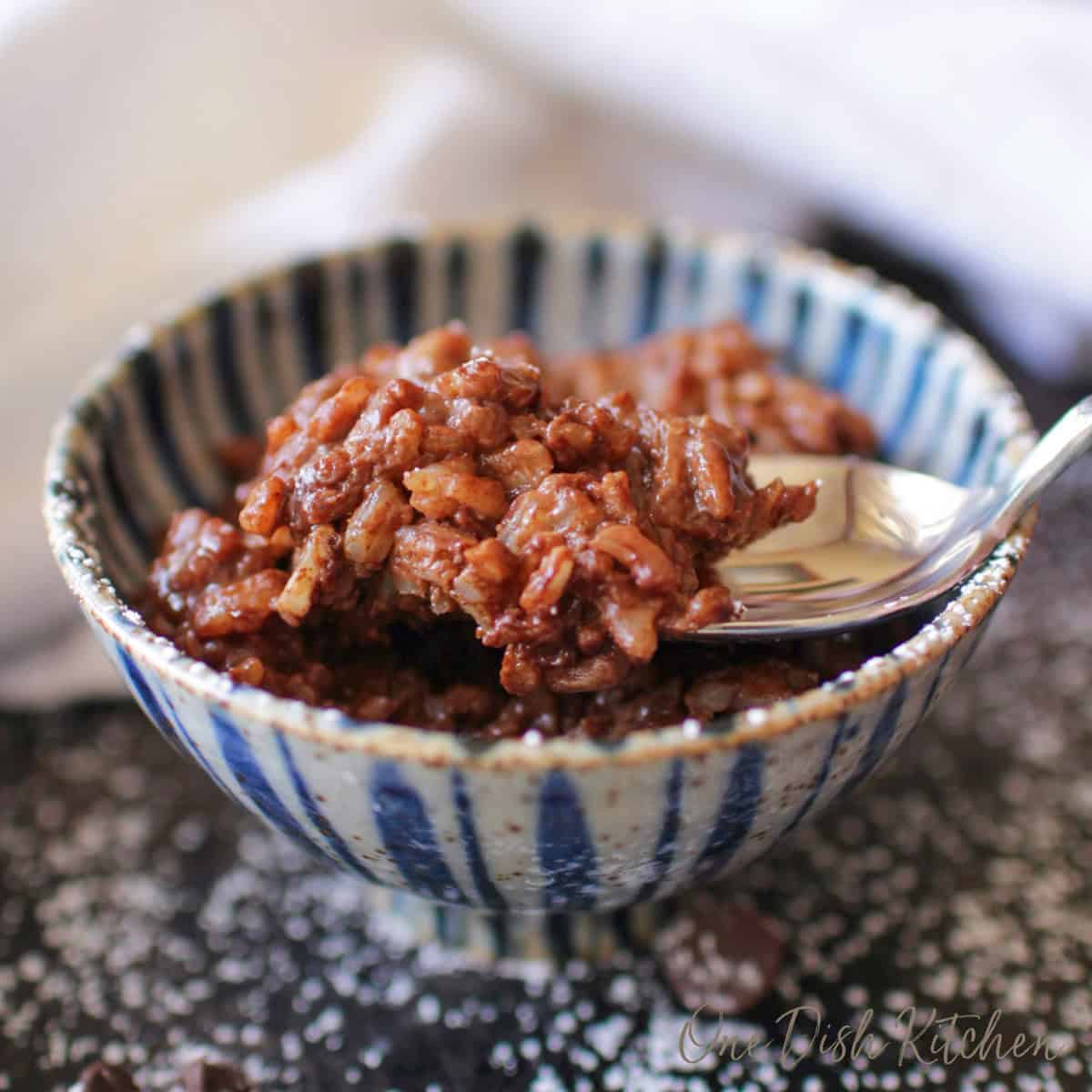 a single serving of chocolate rice pudding in a blue bowl.