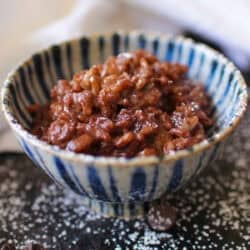 a single serving chocolate rice pudding in a blue bowl.