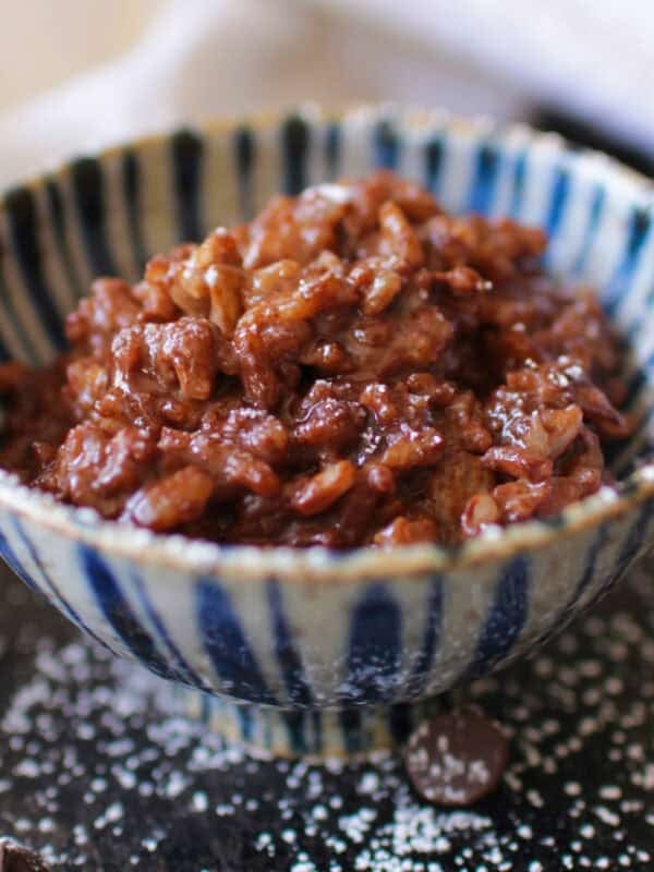 a single serving chocolate rice pudding in a blue bowl.