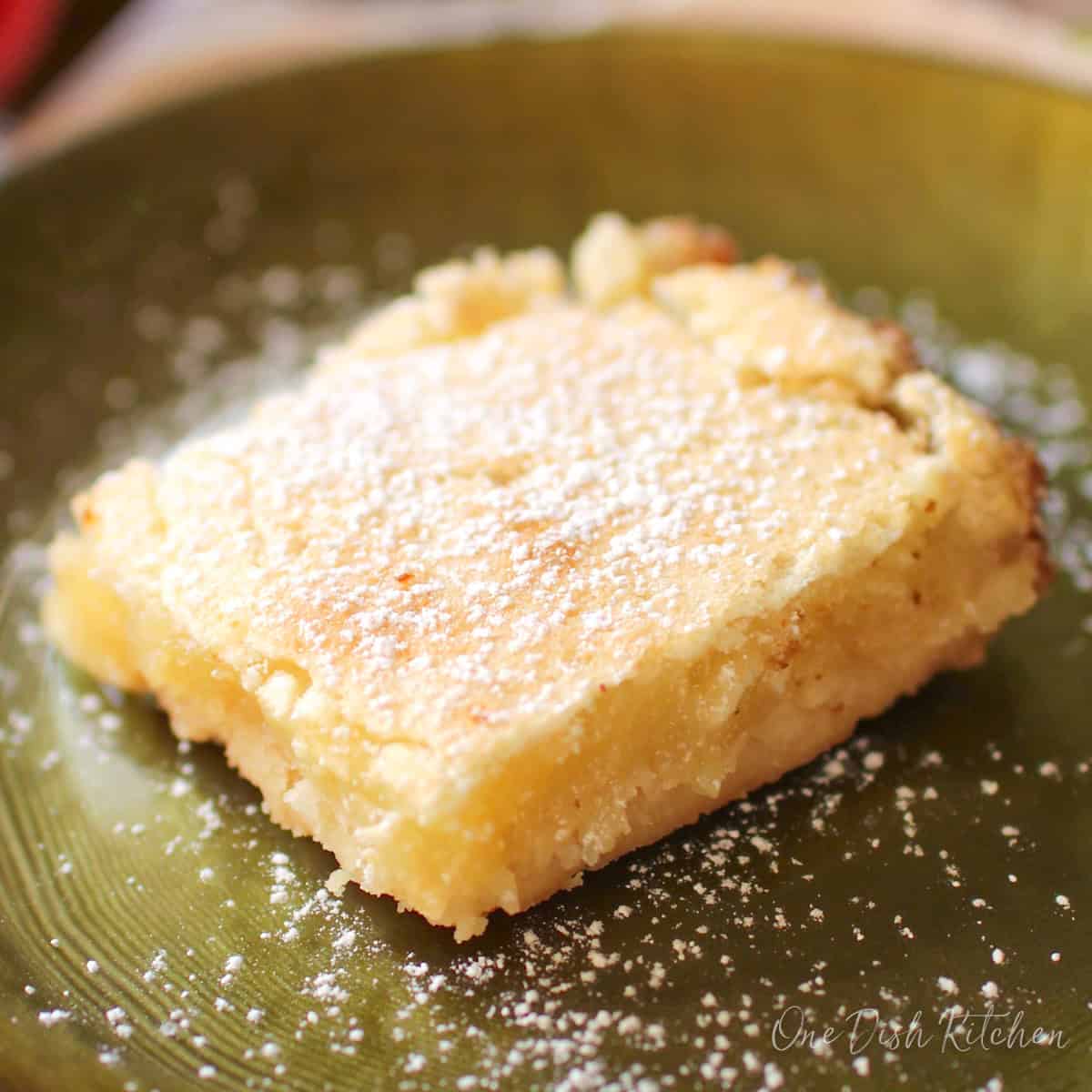 one lemon bar on a green plate.