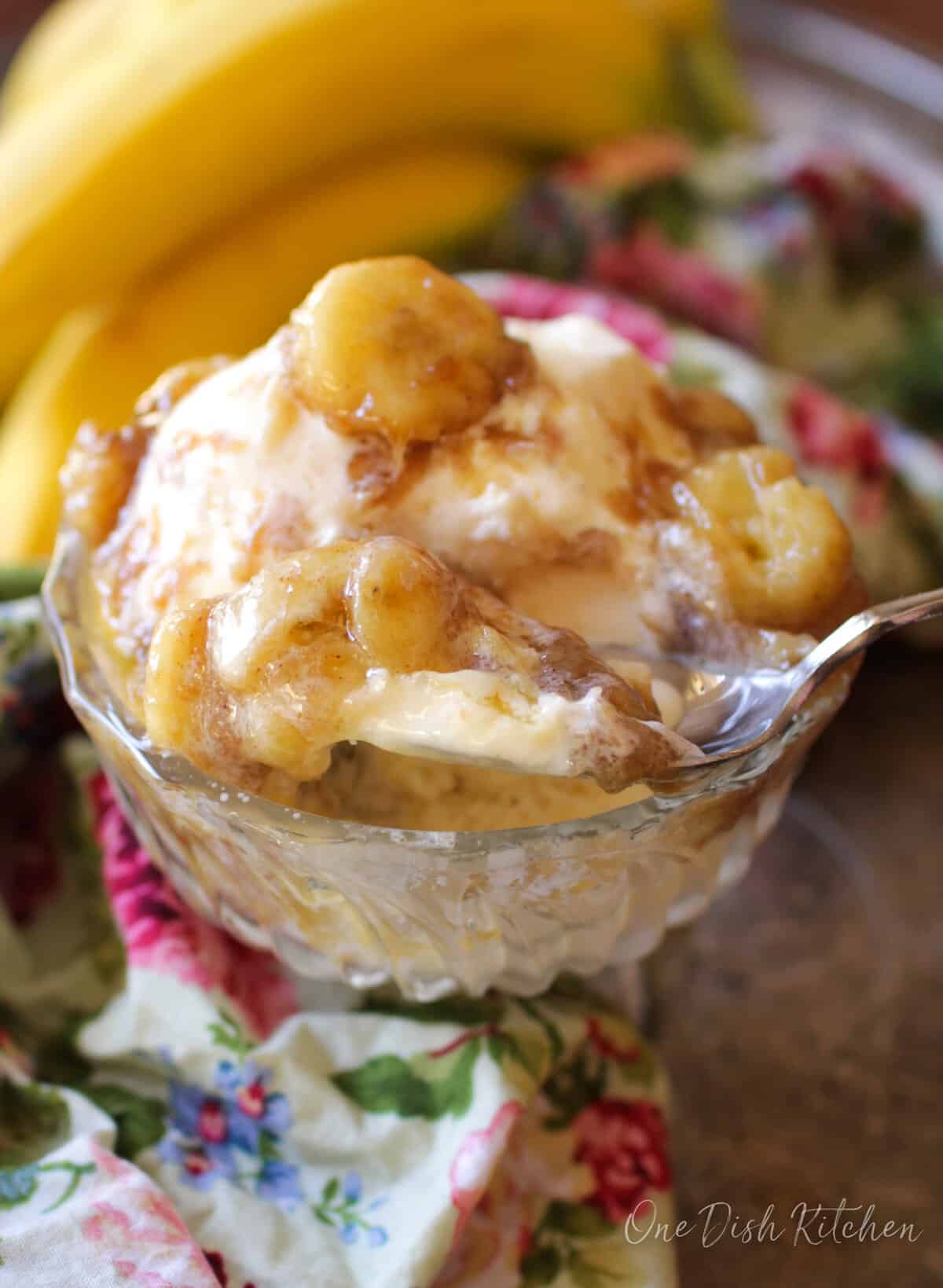 bananas foster over ice cream in a small dessert dish.