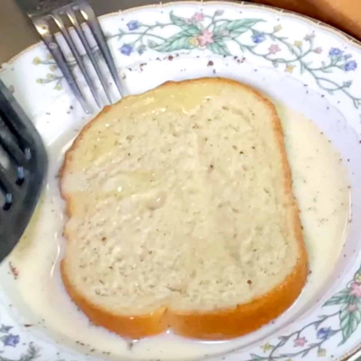 bread soaking in milk and eggs in a bowl.