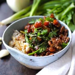 ground pork stir fry in a blue bowl next to onions and parsley