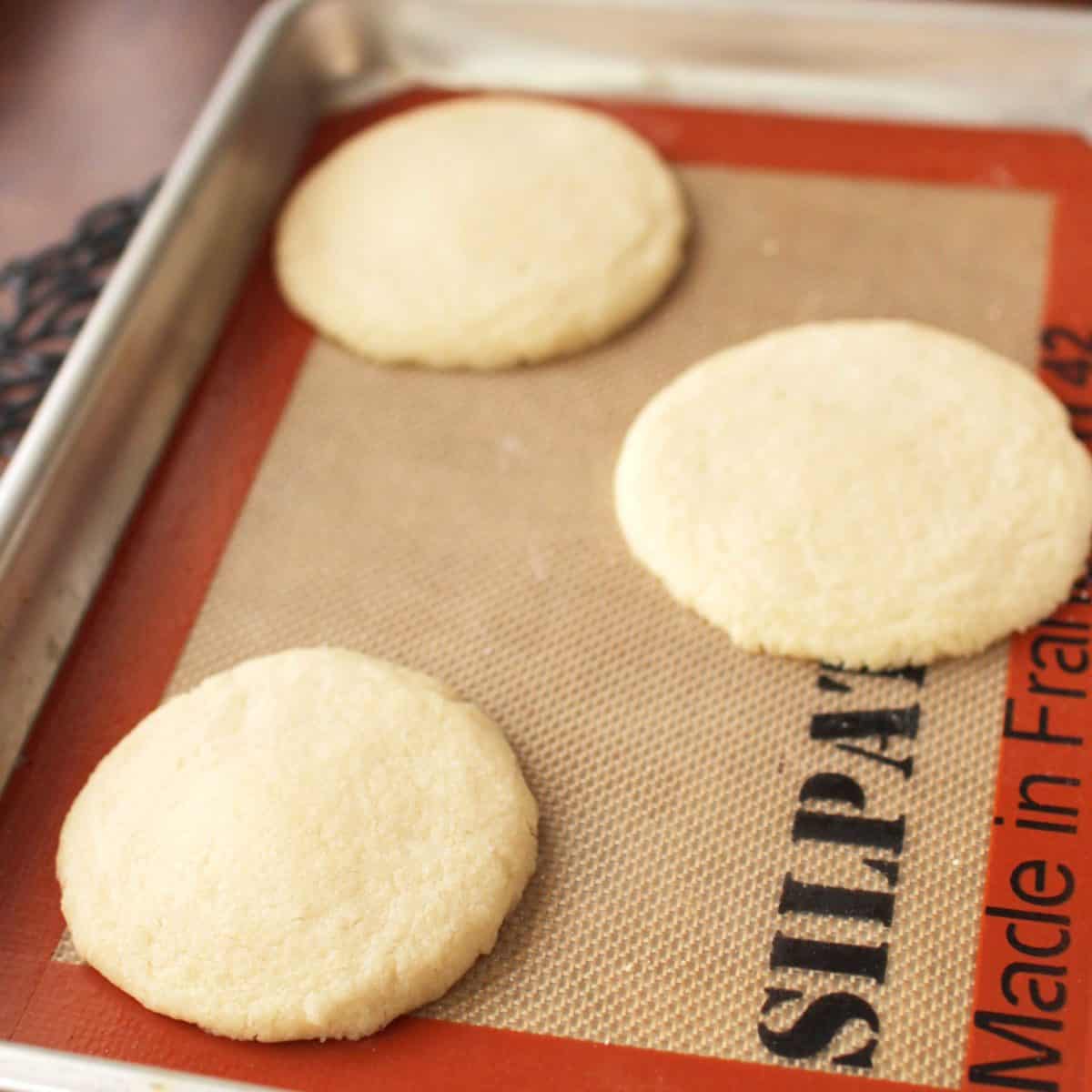 baked shortbread cookies with sugar sprinkled over the top on a silpat liner.