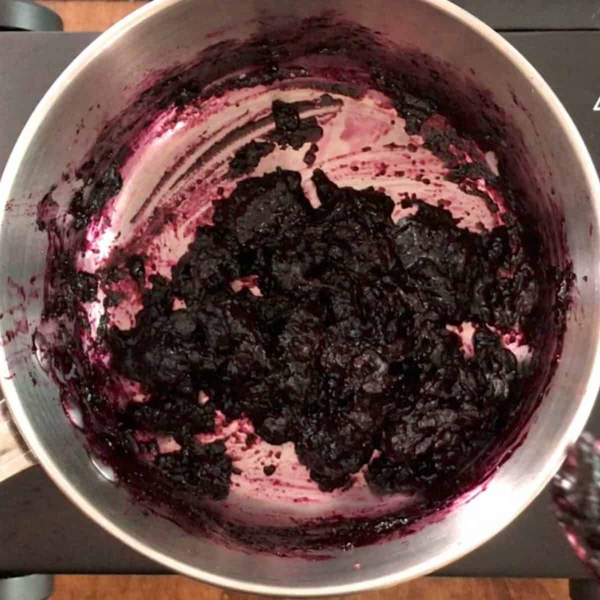 blueberry jam thickening up in a small saucepan.