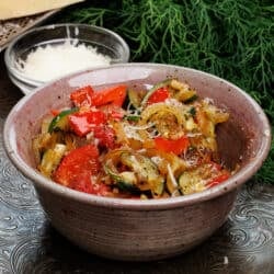 ratatouille in a bowl next to a block of Parmesan cheese